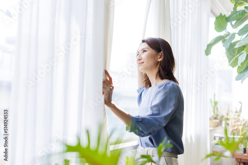 カーテンを開ける女性
