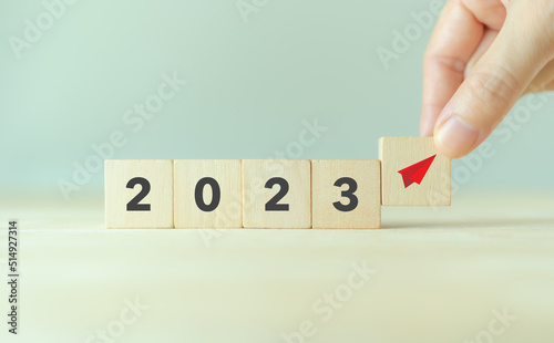 Seeking opportunities concept in 2023. Business for new ideas creativity and innovative solution concept. Putting red paper plane symbol on wooden cube with 2023. Business adaptation and changing.