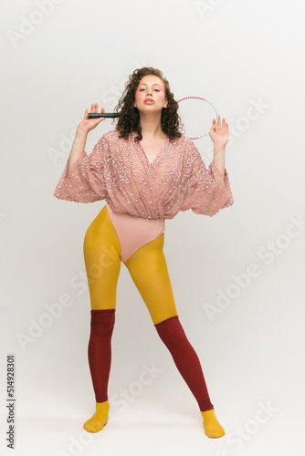 Portrait of young beautiful astonished girl in avant-garde style over white background. Vivid style, beauty, queer, freak, fashion concept. photo