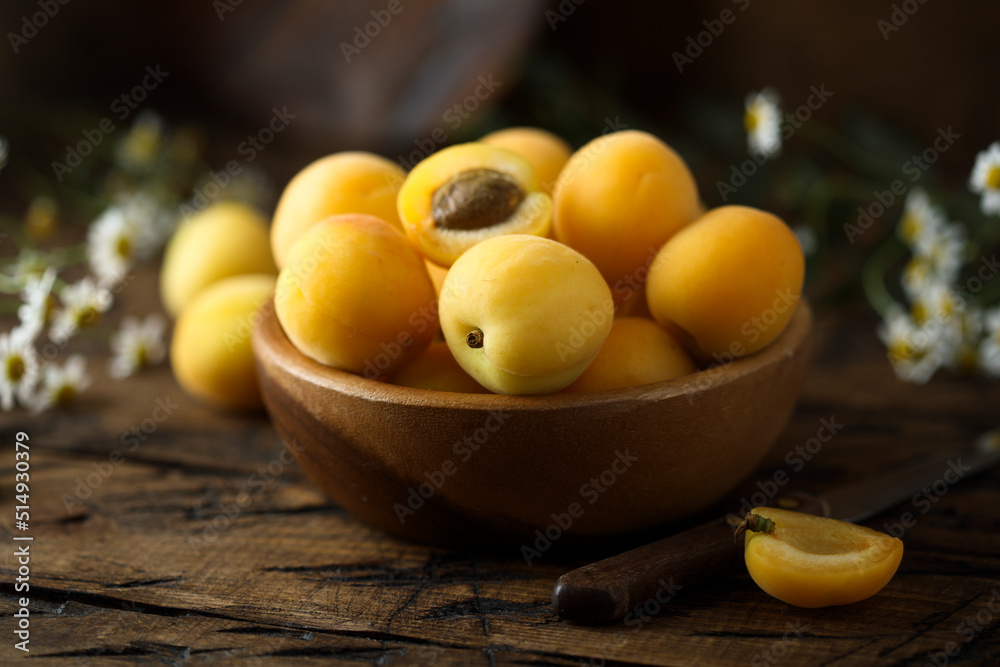 Fresh ripe apricots in a wooden bowl