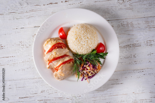 chicken meat with tomatoes, boiled rice and salad