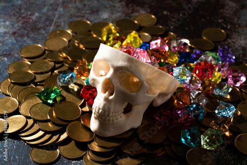 頭蓋骨の模型と金銀財宝のイメージ