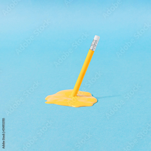 Minimal composition with yellow wooden pancil and liquid on pastel blue background. Surreal writing idea.