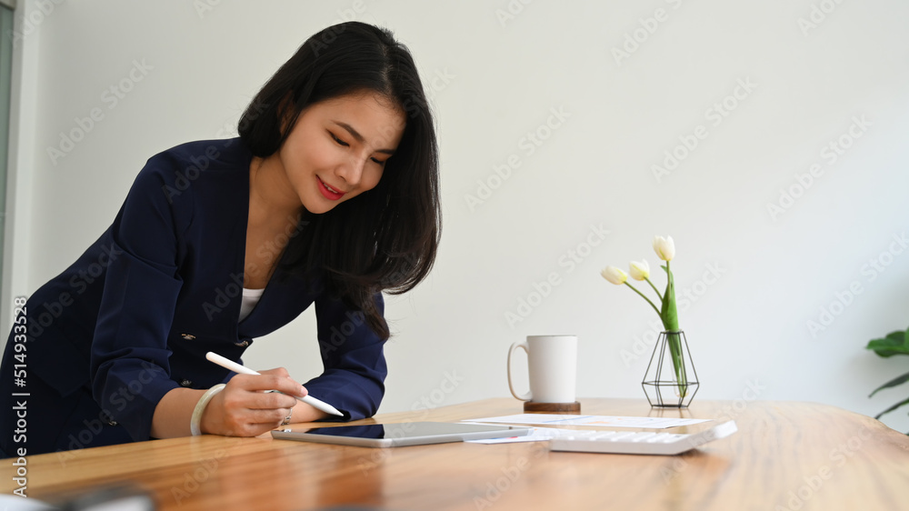Elegant businesswoman checking online information on digital tablet Elegant businesswoman checking online information on digital tablet