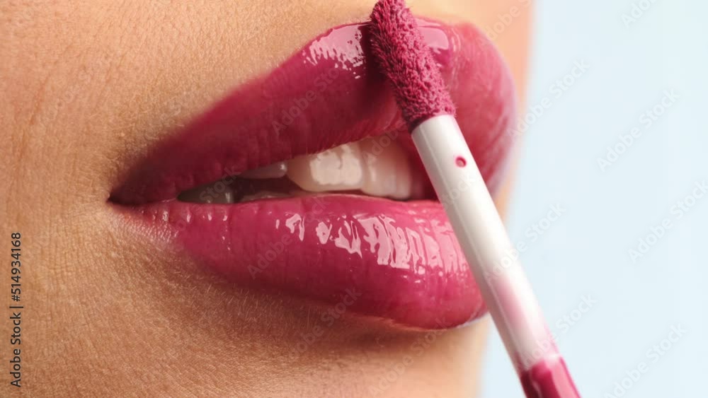 Closeup shot stylist applies lipstick  to the lips of the female model. Woman making make up applying lipstick on a lip. Professional makeup. Tutorial makeup master class. Making mua. Slow motion.