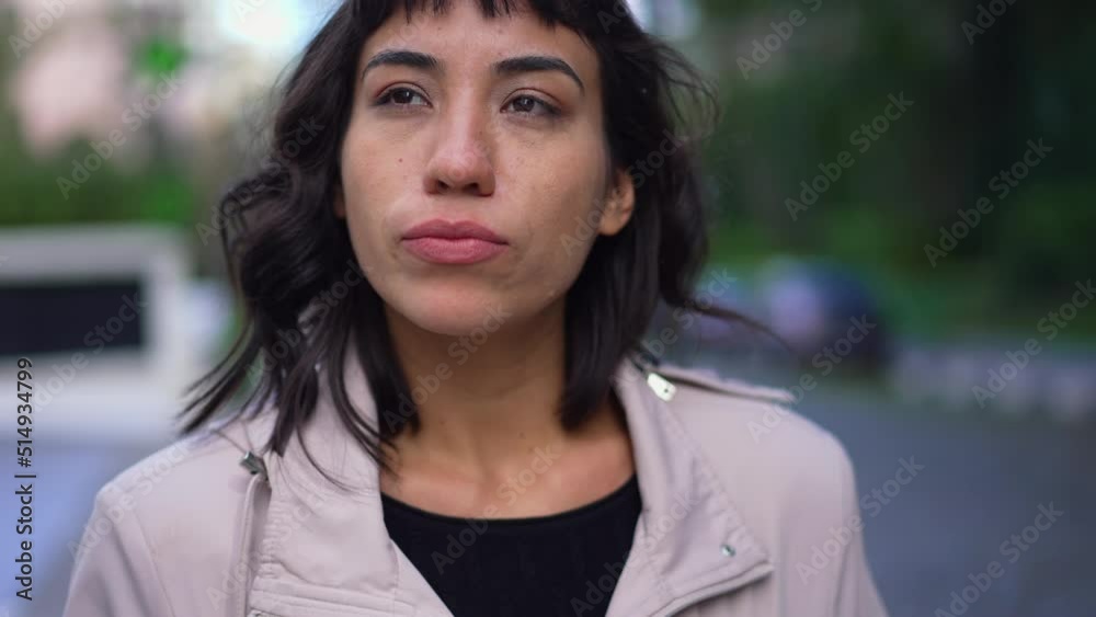 Pensive young woman walking outside in street. One thoughtful hispanic latin person walks in contemplation Pensive young woman walking outside in street. One thoughtful hispanic latin person walks in contemplation