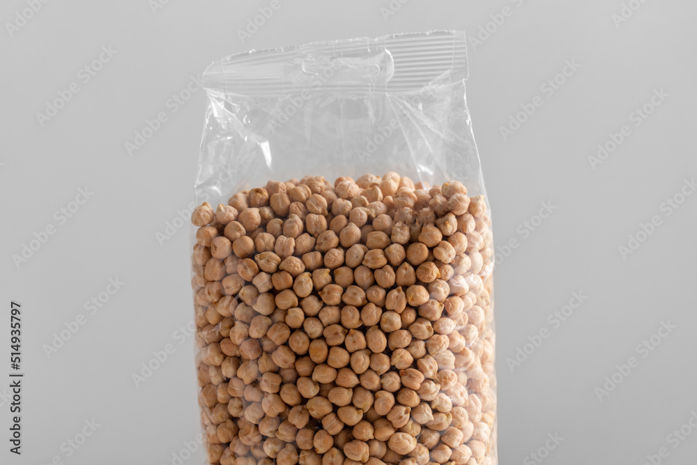 food storage, healthy eating and diet concept - close up of bag with dried peas on grey background