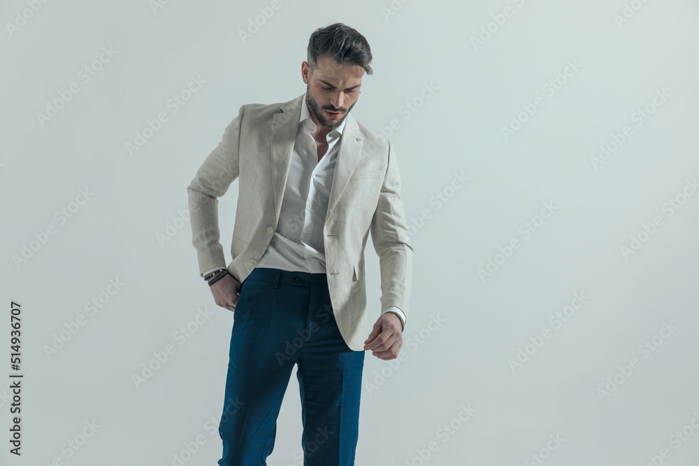 stylish businessman putting hand in pocket and looking down stylish businessman putting hand in pocket and looking down