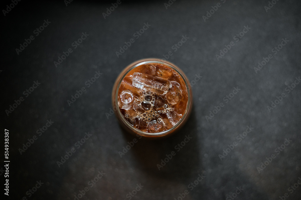 Ice coffee on a table with cream being poured into it showing the texture Ice coffee on a table with cream being poured into it showing the texture