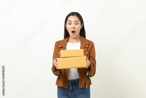 Young excited beautiful asian woman with many parcel cardboard standing on isolated white background. Cheerful female holding lot of parcel box receive from the delivery service © Chanakon