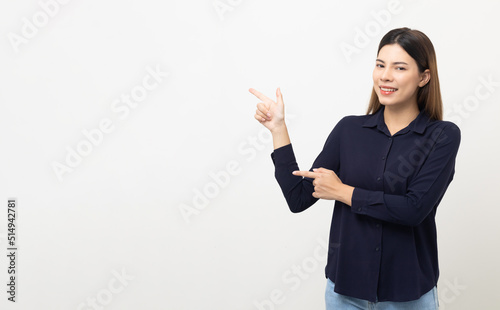 Young beautiful woman pointing finger to copyspace. Happy cheerful female on isolated white background. Pointing to blank space for advertise text.