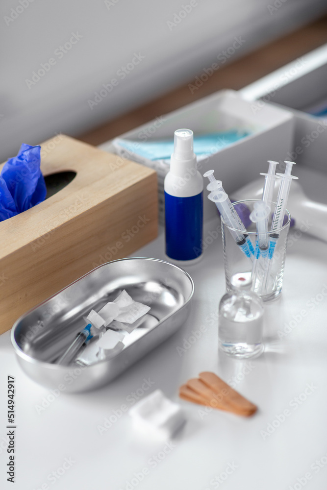 medicine and healthcare concept - close up of syringes, drug in jar and other stuff on table at hospital medicine and healthcare concept - close up of syringes, drug in jar and other stuff on table at hospital