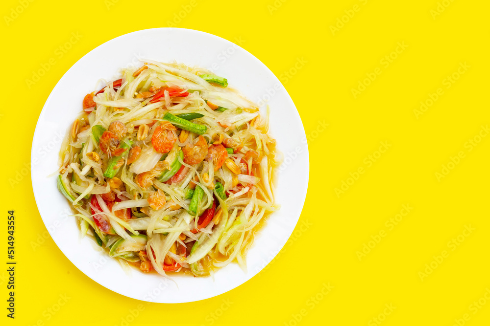Dish of spicy papaya salad on yellow background. Dish of spicy papaya salad on yellow background.