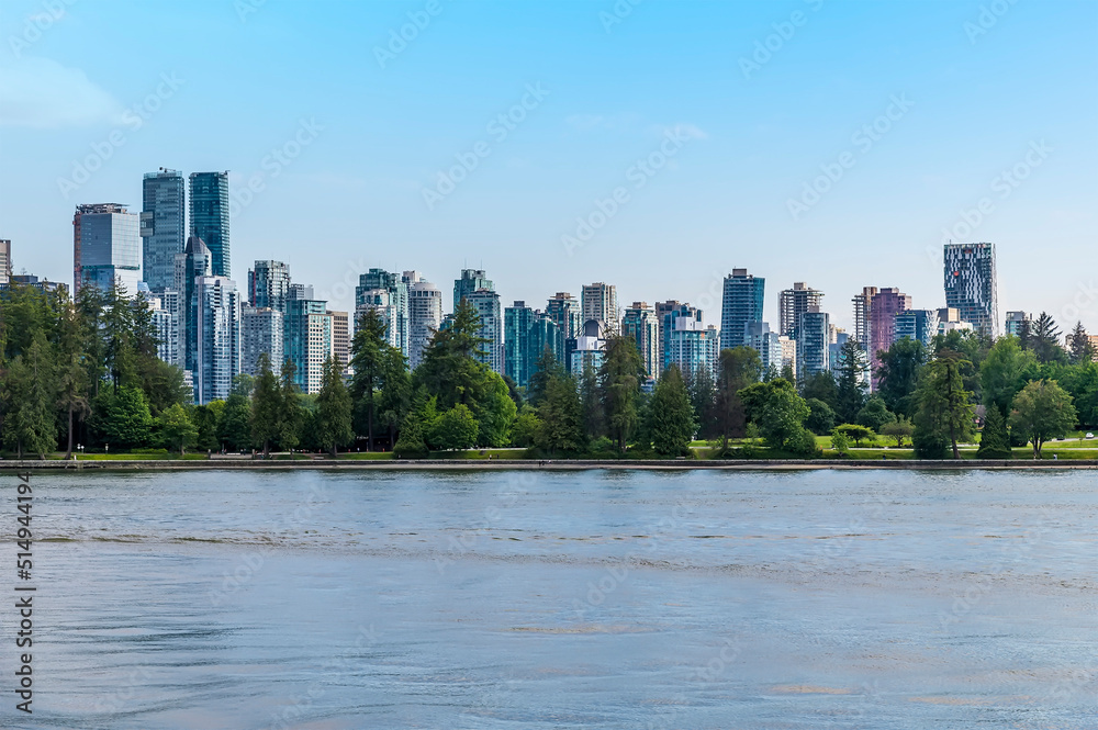 A view from the bay across Stanley Park towards the skyline of Vancouver, Canada in summertime
