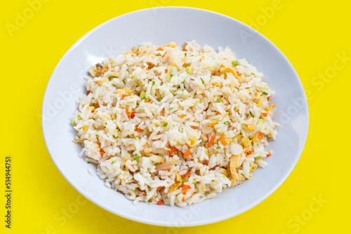 Crab fried rice on white plate on yellow background.