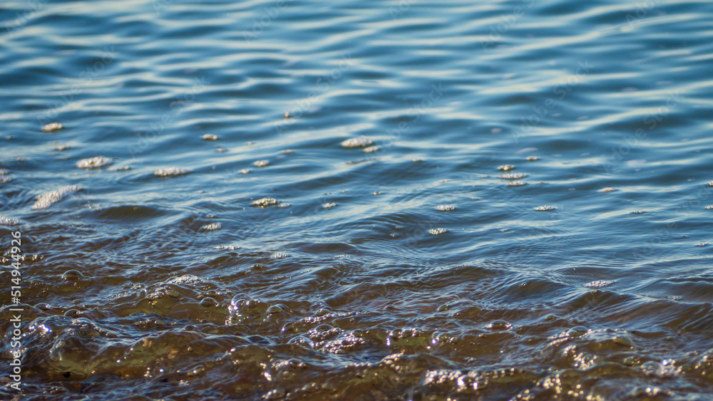 Texture of the background of seawater near the shore. The surface of the seawater near the shore as an abstract background. Abstract background of rippling waves in ocean water Texture of the background of seawater near the shore. The surface of the seawater near the shore as an abstract background. Abstract background of rippling waves in ocean water