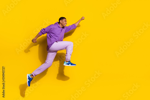 Full length body size view of handsome trendy strong cheerful guy jumping striving isolated on vivid yellow color background © deagreez