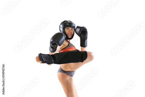 Enegry. Young female kickboxer wearing sports uniform and protective equipment in action isolated on white background. Sport, competition, power concept. photo