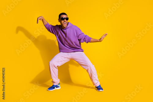 Full length body size view of attractive cheerful guy fooling dancing clubbing isolated over bright yellow color background © deagreez