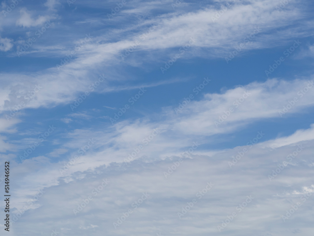 The sky background is a blue sky with white clouds. Cirrus clouds on a blue sky in summer for background