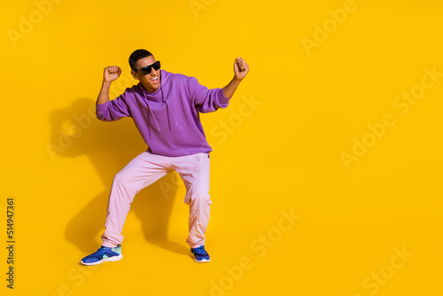 Full length body size view of attractive guy having fun dancing clubbing copy space isolated over bright yellow color background