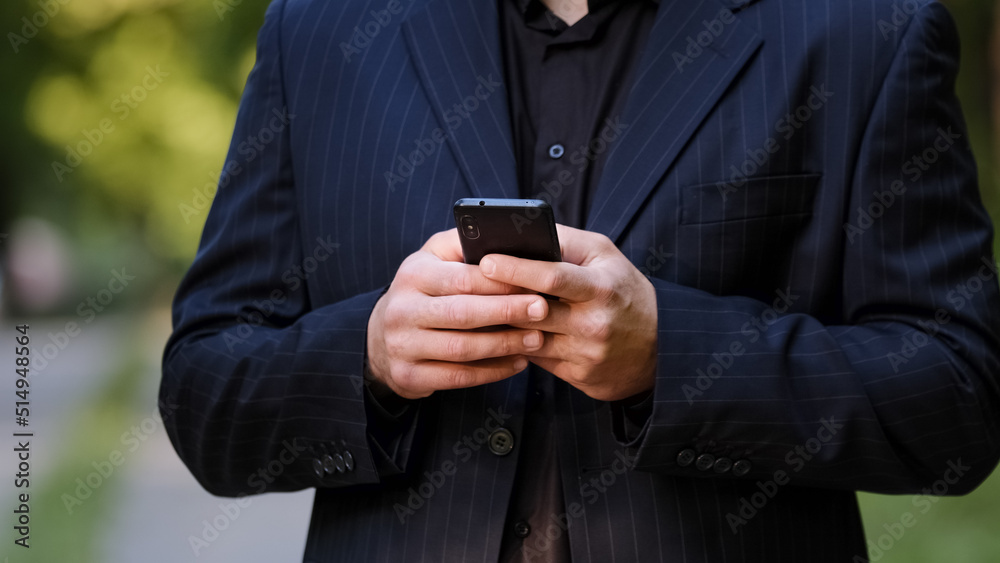 Close up male hands unknown man in black formal suit hold smartphone chatting in social media use mobile app chat texting message search information in internet scroll website page play internet game