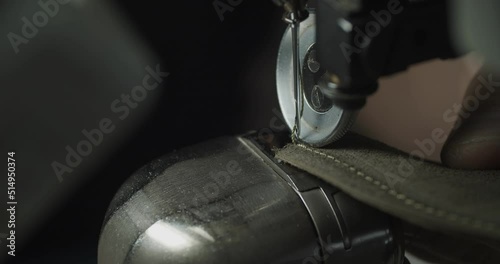 Tailor works on sewing machine in private leather craftshop, making shoes in process. male seamstress sewing leather shoes in leather workshop in 4k
