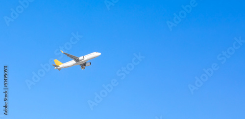 Airplane flying on blue sky background. Aircraft isolated on sky