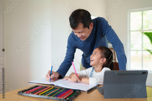 Asian father is teaching little daughter for online learning classroom with happy moment, concept of parent and family, technology, internet connection and homeschooling for kid education