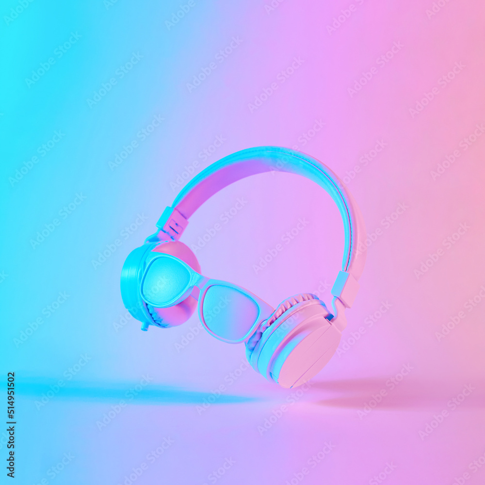 Creative layout made of headphones with sunglasses in vibrant gradient holographic neon colors. Concept art. Minimal music surrealism. Creative layout made of headphones with sunglasses in vibrant gradient holographic neon colors. Concept art. Minimal music surrealism.