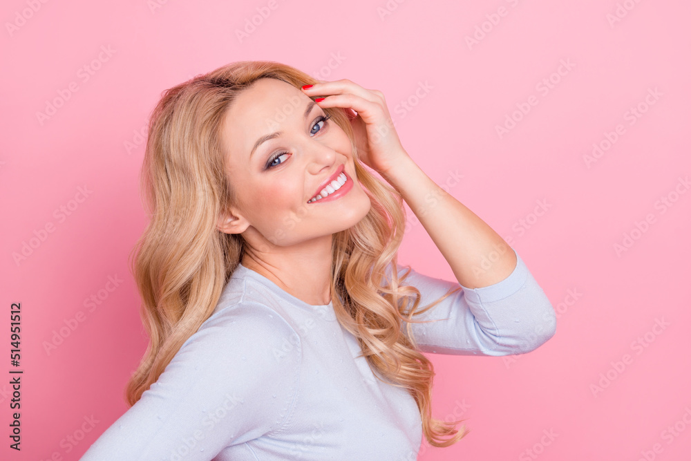 Profile portrait of cheerful satisfied person hand touch curly hair look camera isolated on pink color background Profile portrait of cheerful satisfied person hand touch curly hair look camera isolated on pink color background