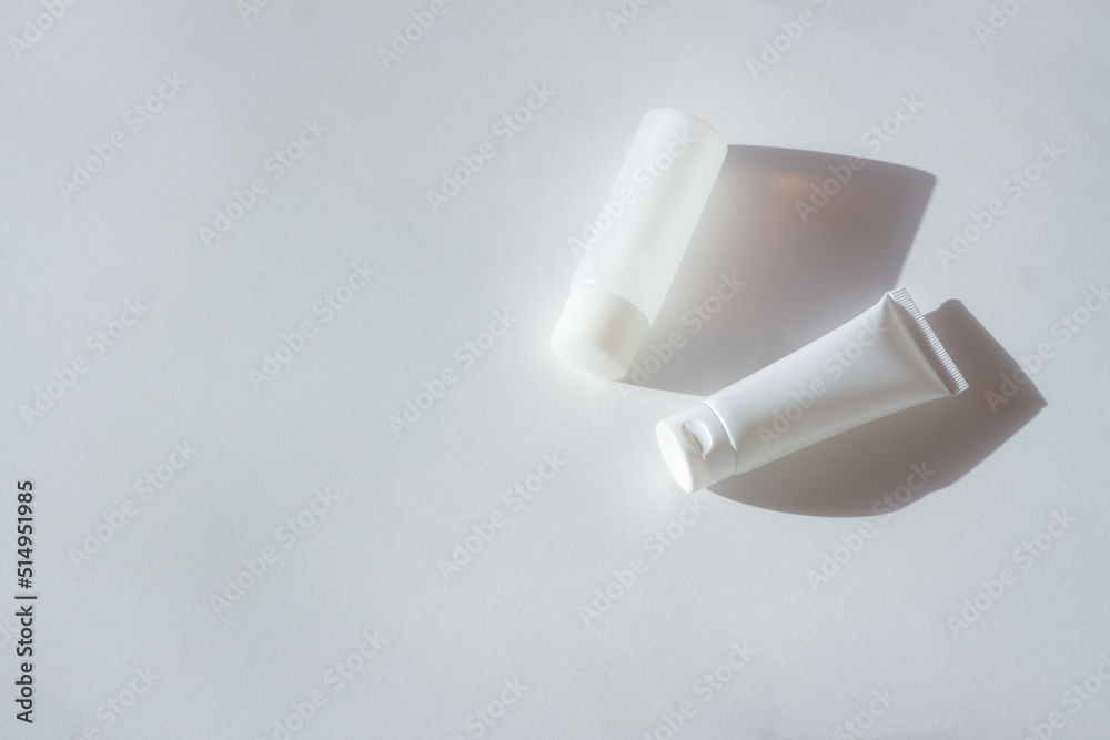 Cosmetic bottles with shadow on white wall background Cosmetic bottles with shadow on white wall background