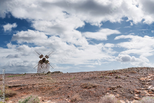 old windmill on Fuerteventura, Canary Islands, against blue sky with clouds photo