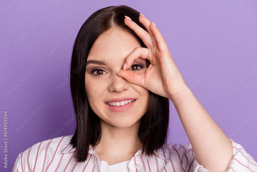 Photo of young cheerful lady show fingers okey symbol eye look watch specs isolated over violet color background Photo of young cheerful lady show fingers okey symbol eye look watch specs isolated over violet color background