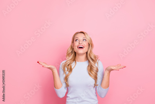 Photo of satisfied lady arms hold catch look empty space isolated on pink color background