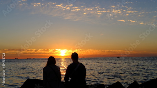 Lovers in front of a summer sunset on the Baltic bay  Mangalsala  lighthouse