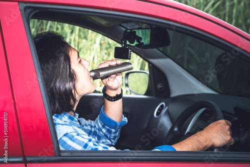 Portrait images of Asian man are drinking alcohol while he was driving, to people and drunk driving, causes of accidents concept.