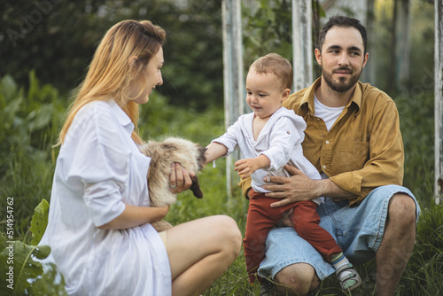 Father, mother and their son are playing with a cat. Family pet. Family time. A happy family. © Anastasia
