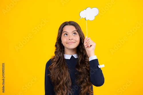 Teenager child girl holding thinking bubble, comment cloud over yellow background. © Olena