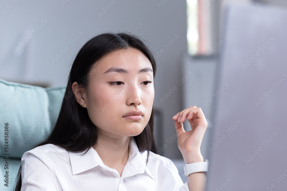 Close-up photo portrait of a young Asian woman office worker, wearing a white shirt, working in the office, looking at the monitor. Close-up photo portrait of a young Asian woman office worker, wearing a white shirt, working in the office, looking at the monitor.