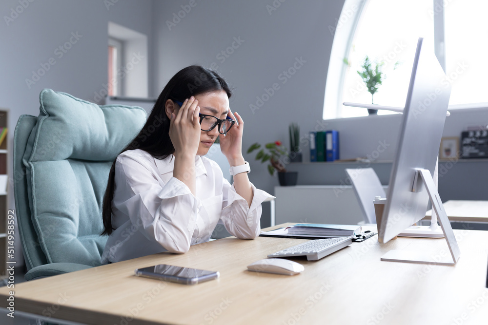 Asian business woman sick working in office, having severe headache, holding hands on head in depression and sad. Asian business woman sick working in office, having severe headache, holding hands on head in depression and sad.