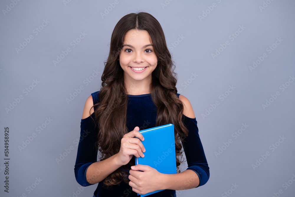 Back to school. Teenager schoolgirl hold book and copybook ready to learn. School children on isolated grey background. Happy face, positive and smiling emotions of teenager girl. Back to school. Teenager schoolgirl hold book and copybook ready to learn. School children on isolated grey background. Happy face, positive and smiling emotions of teenager girl.