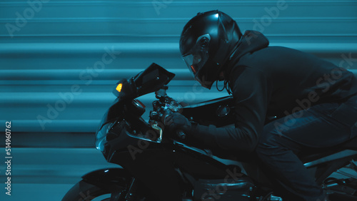 A man rides a sports motorcycle through the city at night