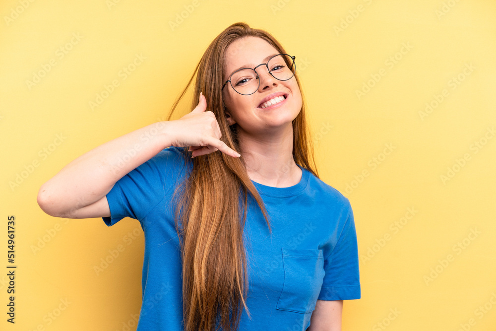 Young caucasian woman isolated on yellow background showing a mobile phone call gesture with fingers. Young caucasian woman isolated on yellow background showing a mobile phone call gesture with fingers.