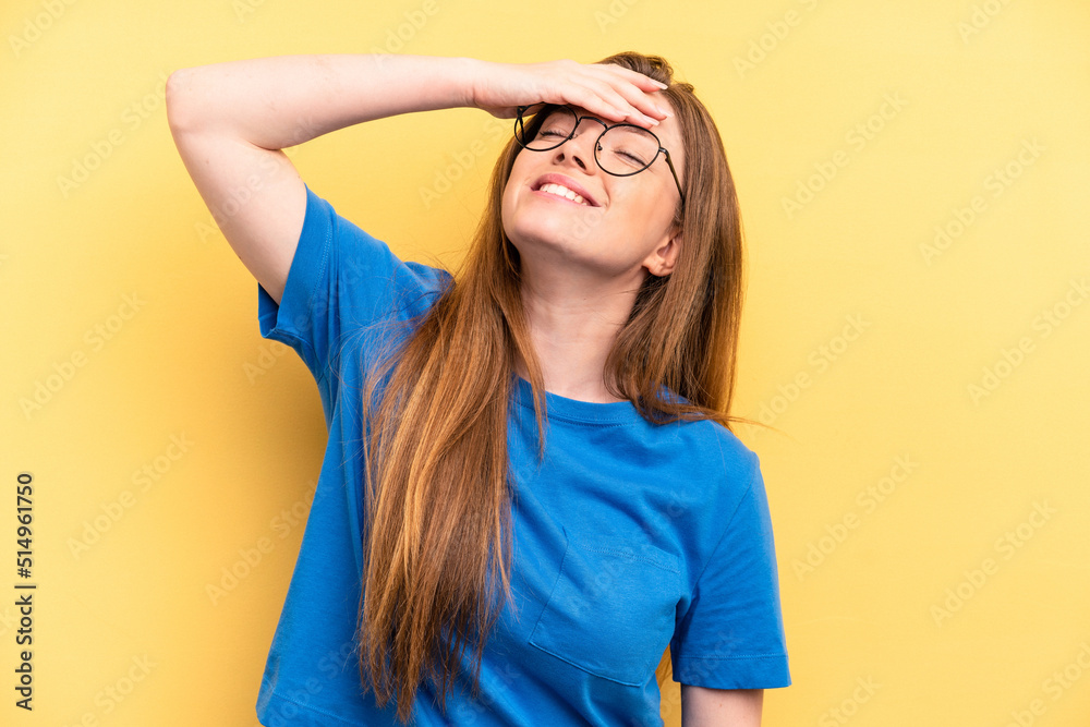 Young caucasian woman isolated on yellow background laughs joyfully keeping hands on head. Happiness concept.