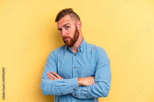 Young caucasian man isolated on yellow background unhappy looking in camera with sarcastic expression. © Asier