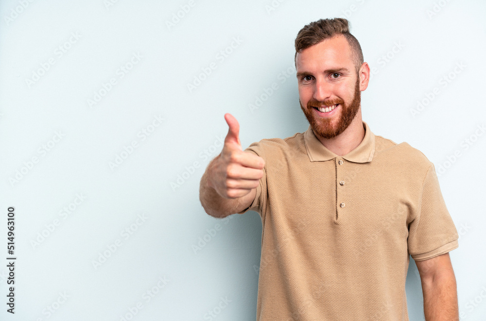 Young caucasian man isolated on blue background smiling and raising thumb up Young caucasian man isolated on blue background smiling and raising thumb up