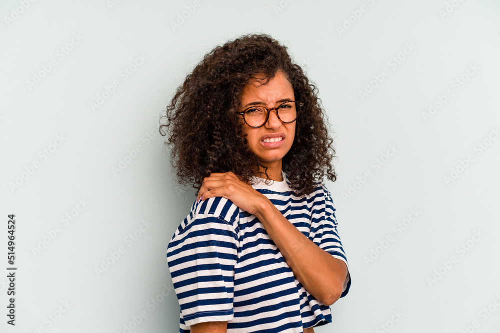 Young Brazilian woman isolated on blue background having a shoulder pain.