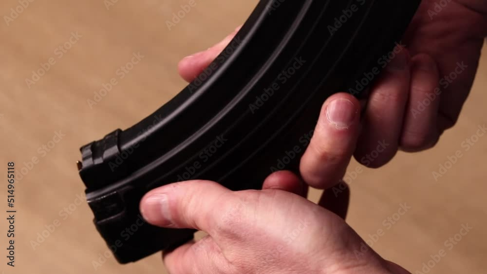 Male hands with kalashnikov assault rifle magazine with cartridges