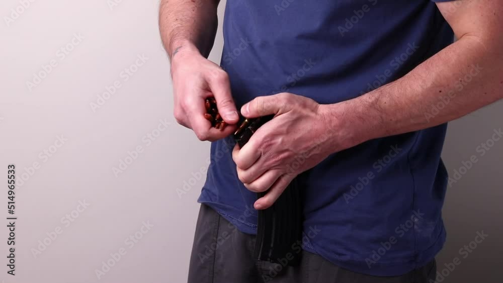 Magazine Loading Rifle Man loading Kalashnikov assault rifle magazine with cartridges. Load ...